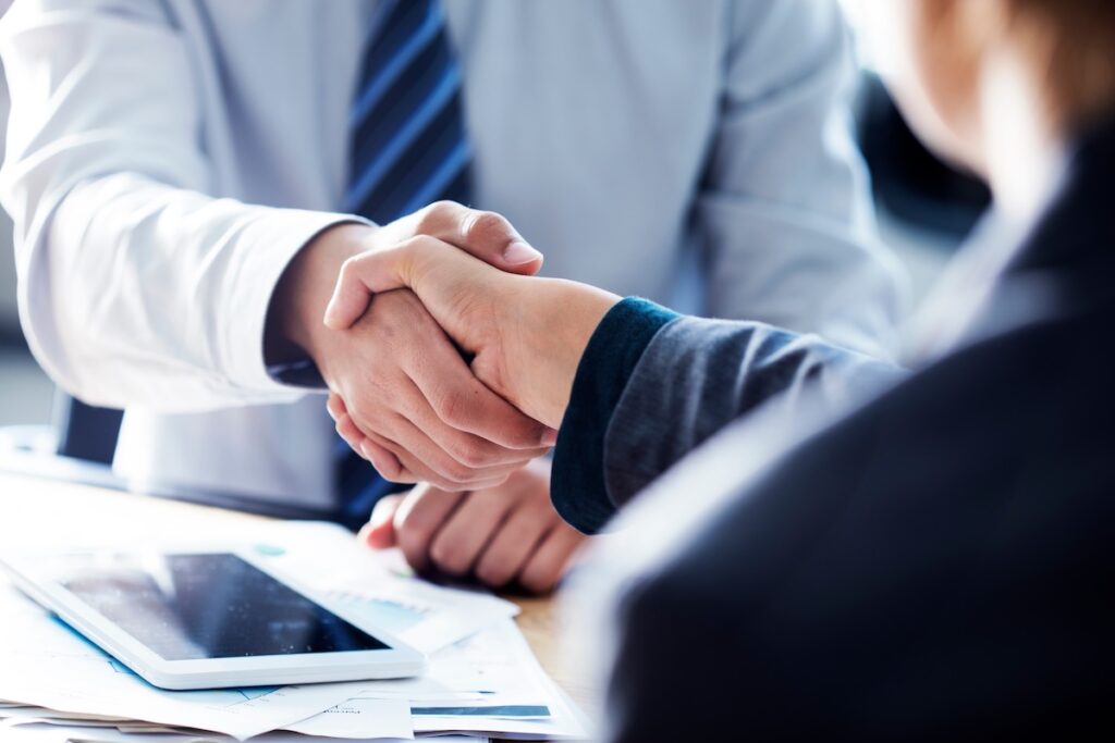 Two people shaking hands in professional business wear