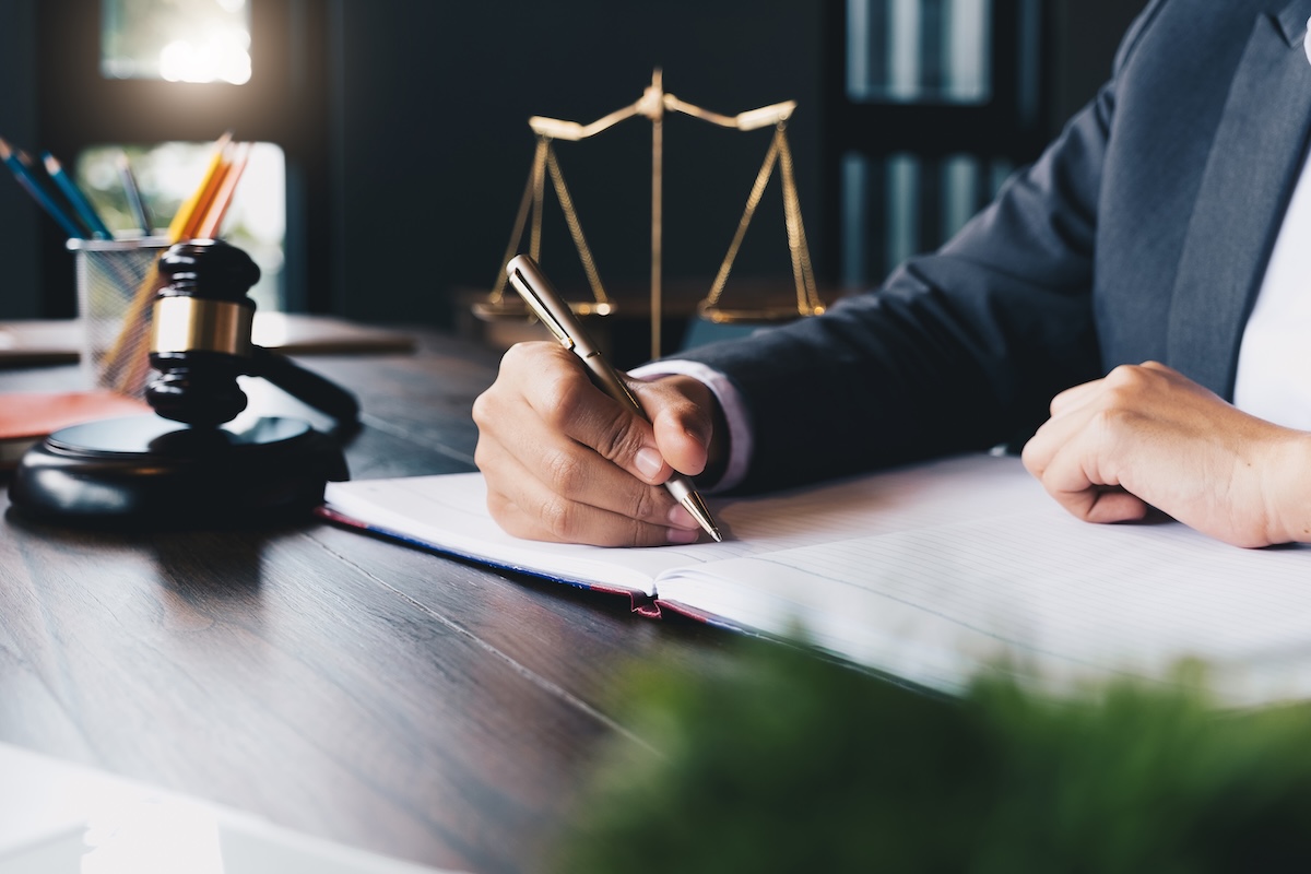 Lawyer working at desk writing something on a piece of paper