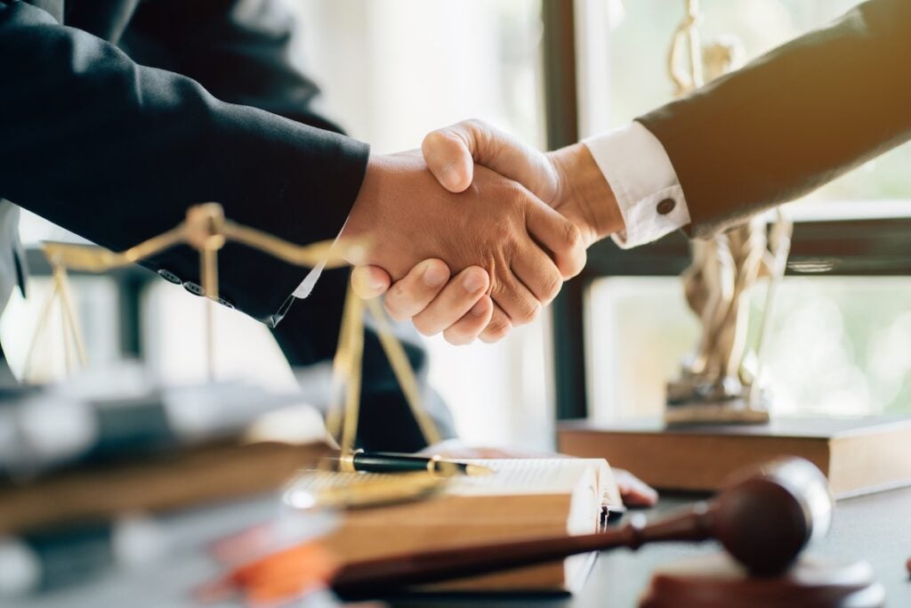Shaking hands with lawyer at desk