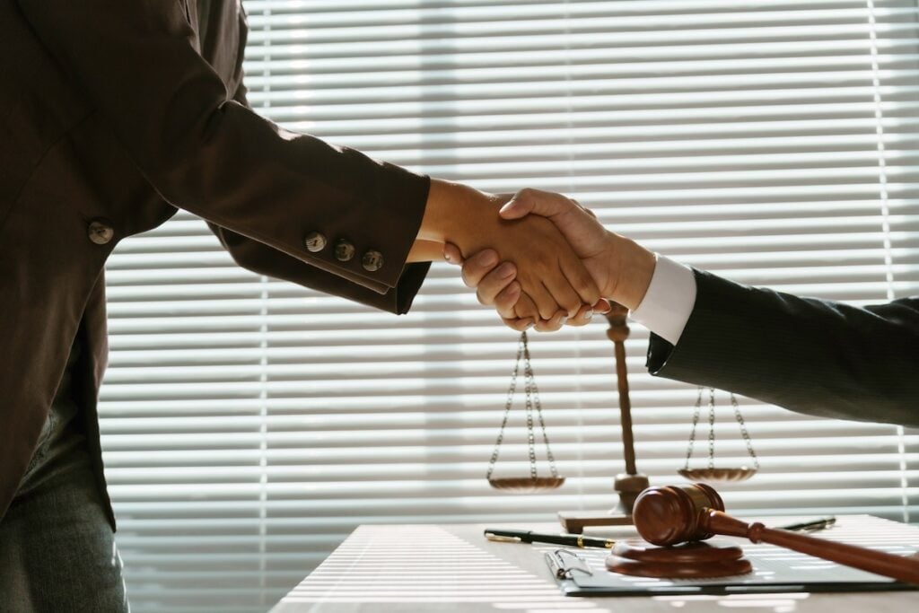 lawyers and client shaking hands after reaching an agreement 