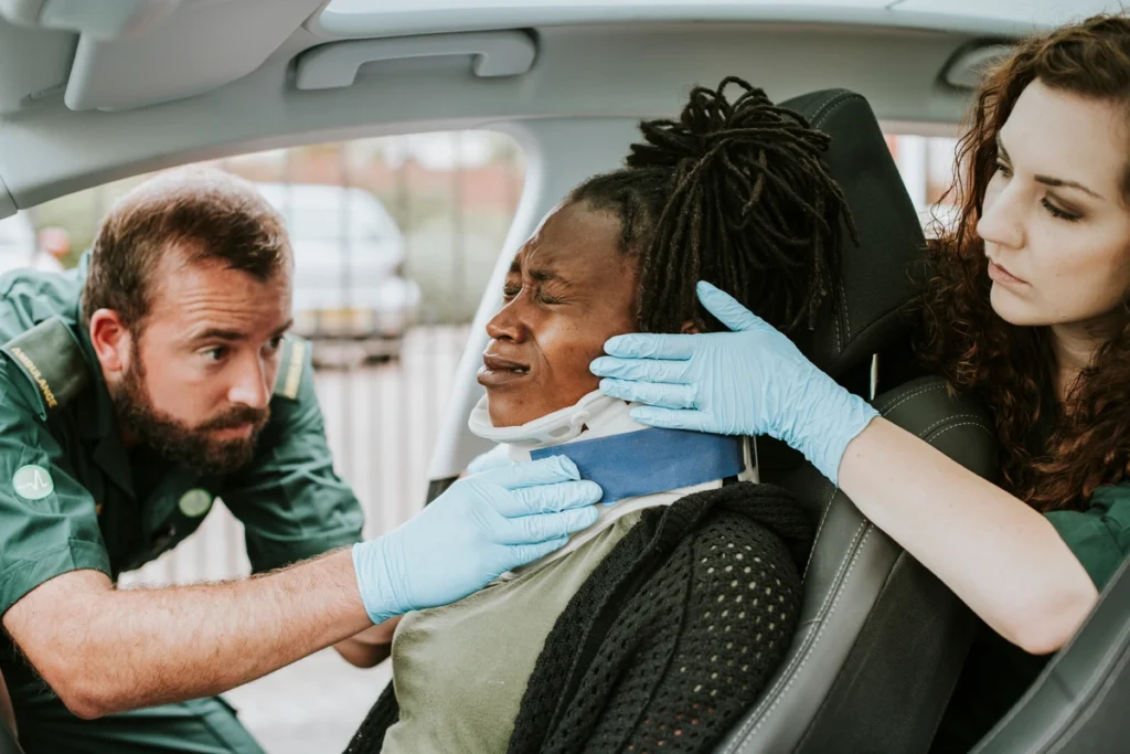 two ambulance workers attending to her in the car after a car accident
