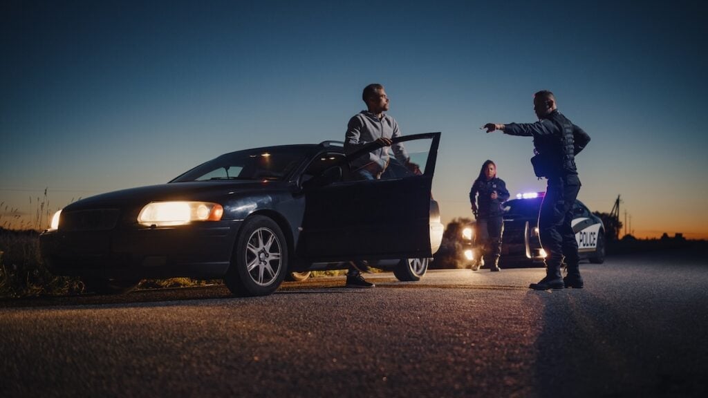 Professional Officer Ordering a Driver to Get Out of the Vehicle and Put His Hands on the Hood of his Car