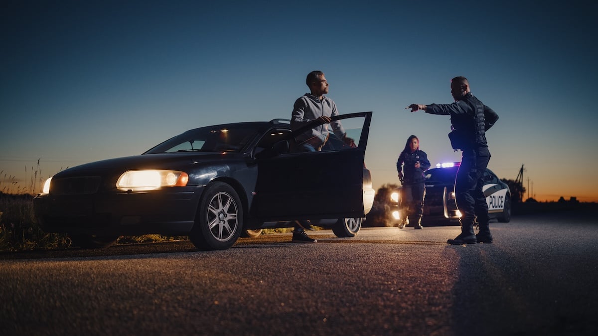 Professional Officer Ordering a Driver to Get Out of the Vehicle and Put His Hands on the Hood of his Car