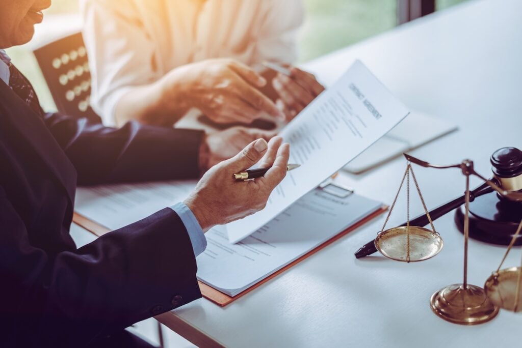 lawyers discussing and sign a contract in meeting room.