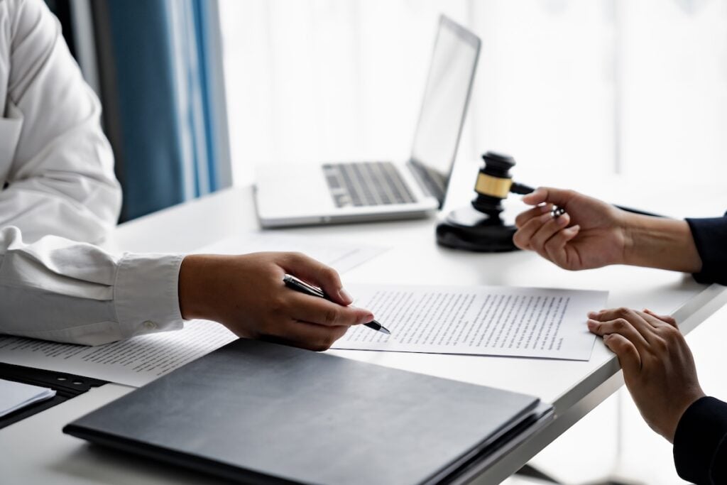 serious courtroom lawyer preparing litigation documents for business client before official hearing