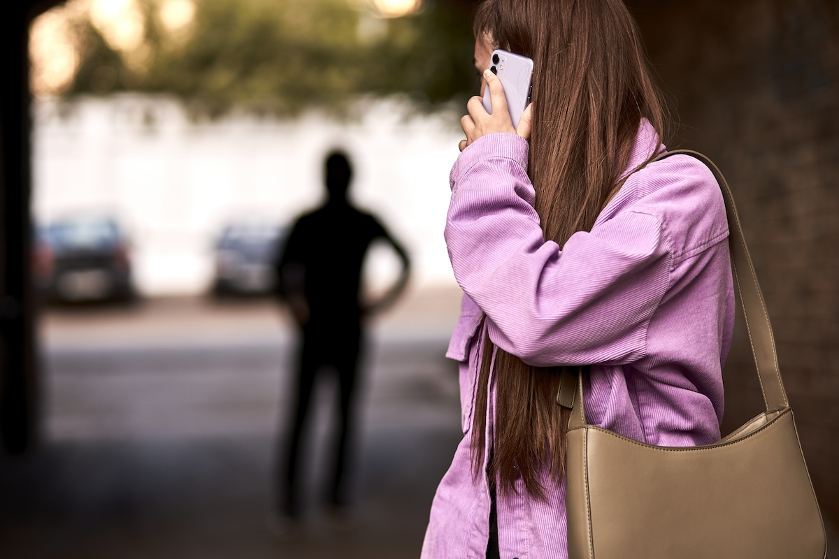 man standing behind woman on the phone