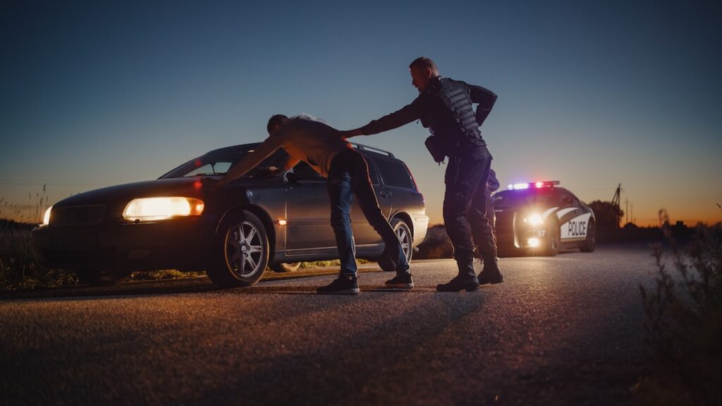 Policeman Performing a Pat-Down Search on a drunk driver
