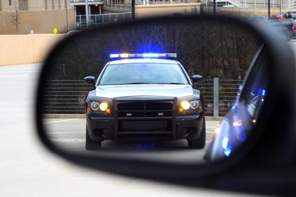Police Stop cop car in view through side mirror