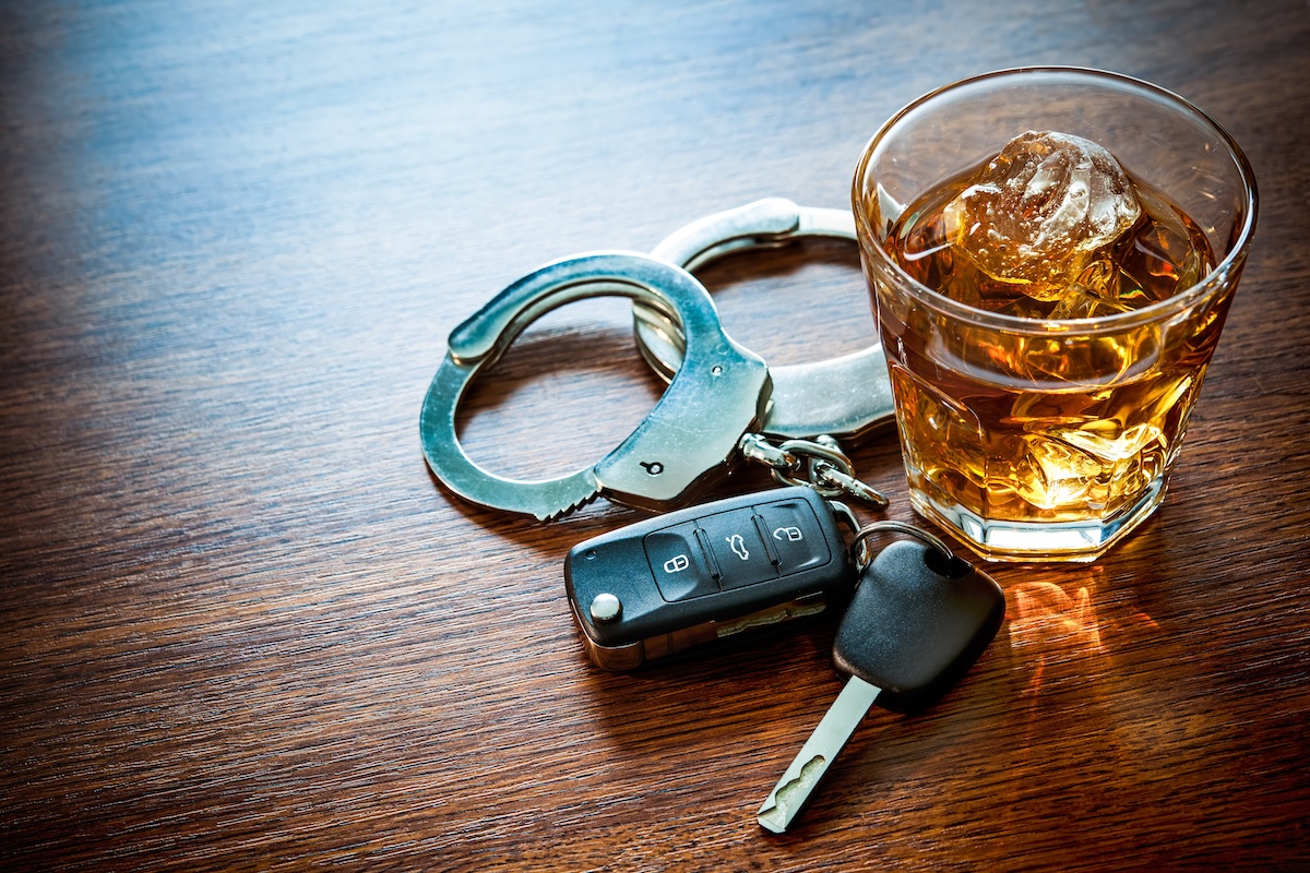 Whiskey with car keys and handcuffs concept for drinking and driving