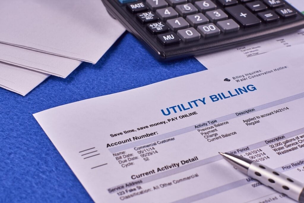 Utility billing sheet, calculator, pen and envelope