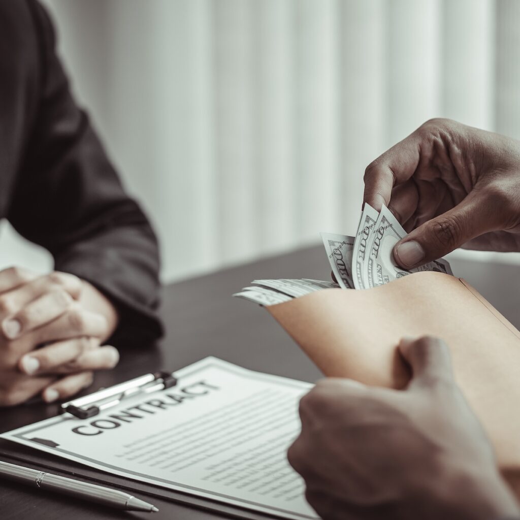 Businessmen give dollars to bribe employees in signing contracts to buy illegal land and real estate, Business fraud and social injustice, corruption and bribery concept.